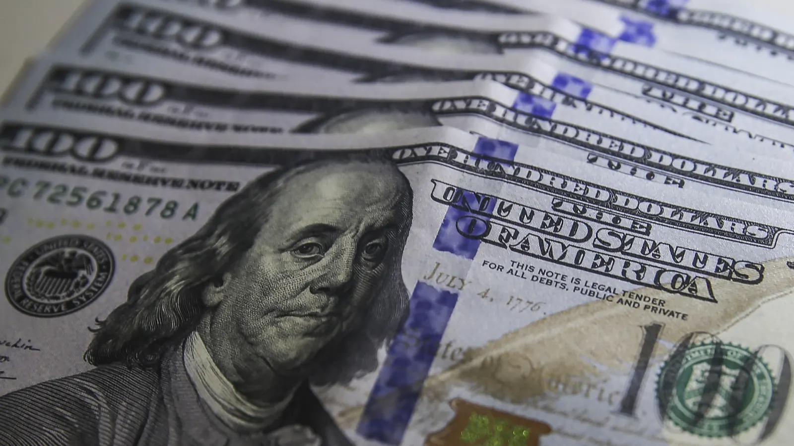 Cédulas de dólar norte-americano espalhadas sobre uma mesa