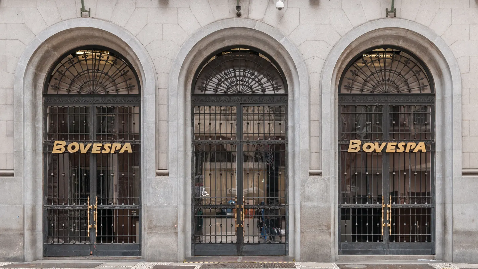 Fachada do antigo prédio da Bovespa, no centro de São Paulo, com portões de ferro em arco e o letreiro dourado Bovespa
