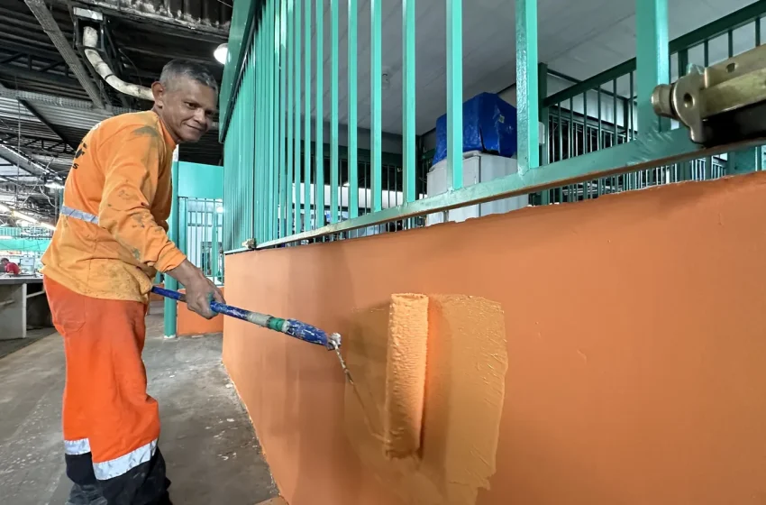 Trabalhador pinta estrutura durante obra de revitalização de feira em Manaus