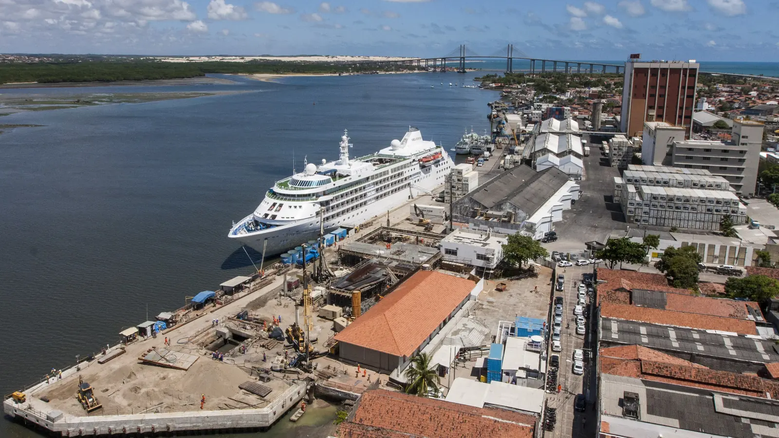 Vista aérea do Porto de Natal, com navio de cruzeiro atracado no cais às margens do Rio Potengi e a Ponte Newton Navarro ao fundo