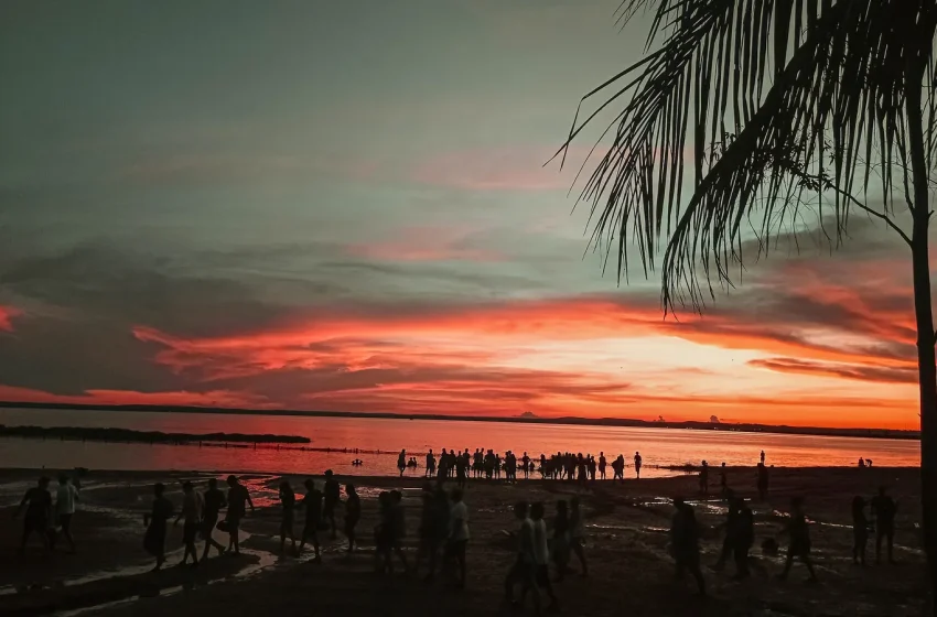Pôr do sol alaranjado sobre o lago na Praia da Graciosa, em Palmas